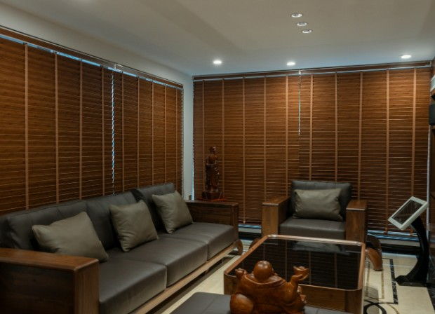 Salón acristalado con venecianas de madera a medida en sus tres paredes de ventanales